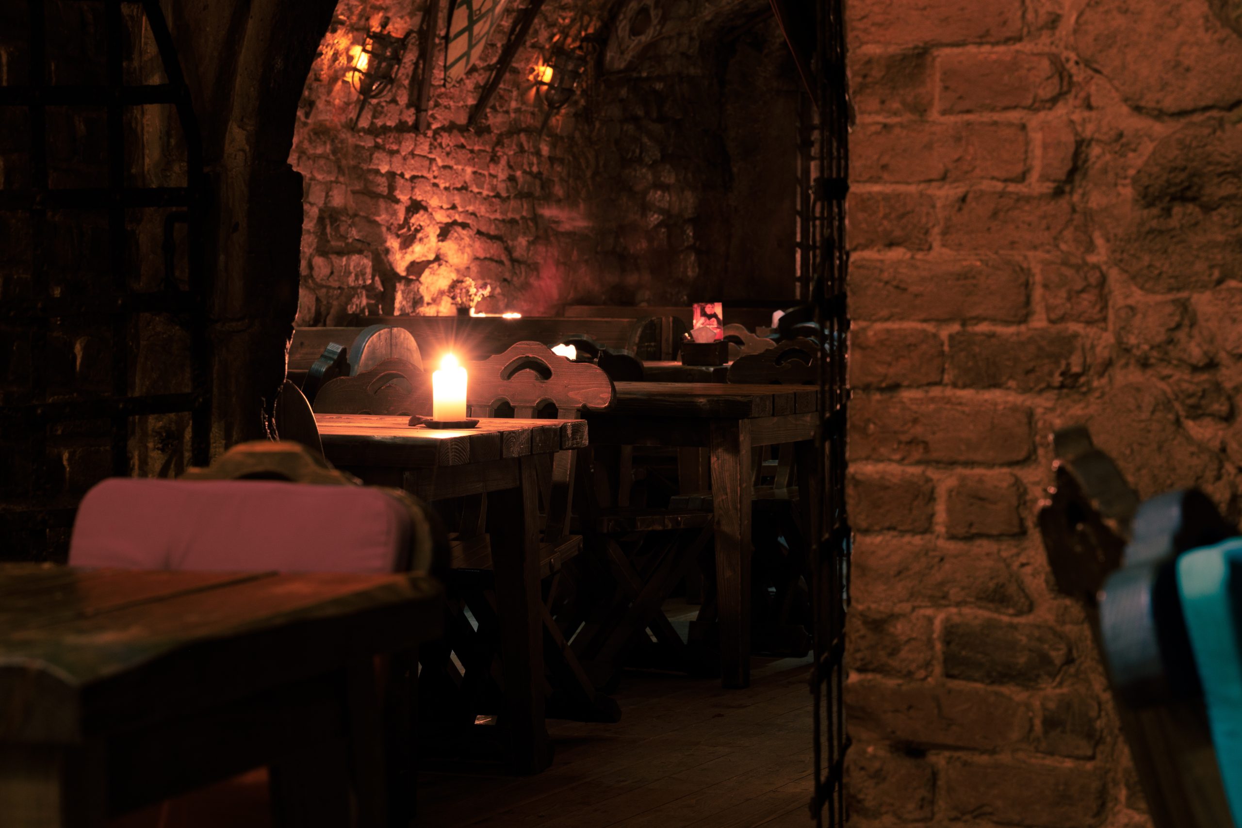 dungeon tavern fantasy bar aesthetic of role play place warm candle light interior of underground brick walls and tables no people here
